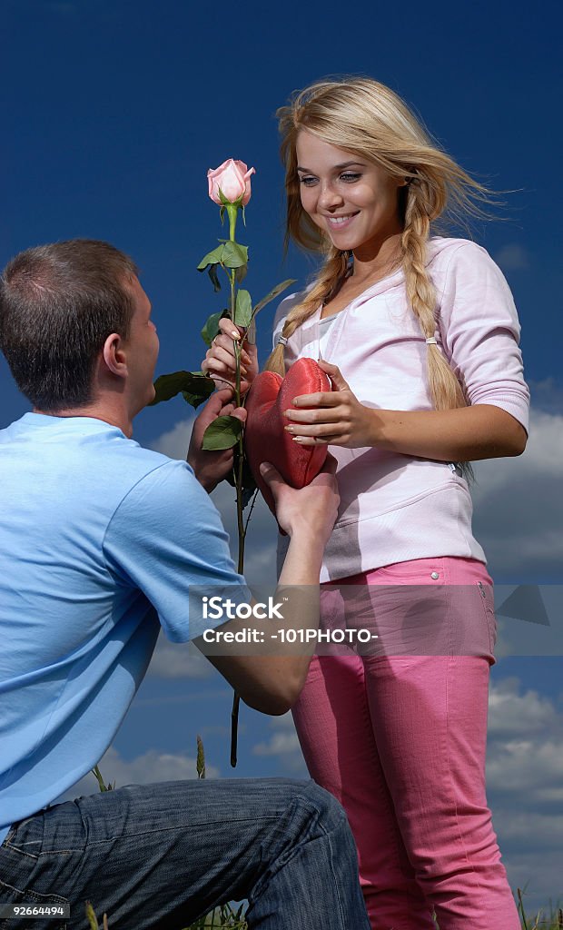 Młody człowiek daje Róże do dziewczyny i serca - Zbiór zdjęć royalty-free (Chmura)