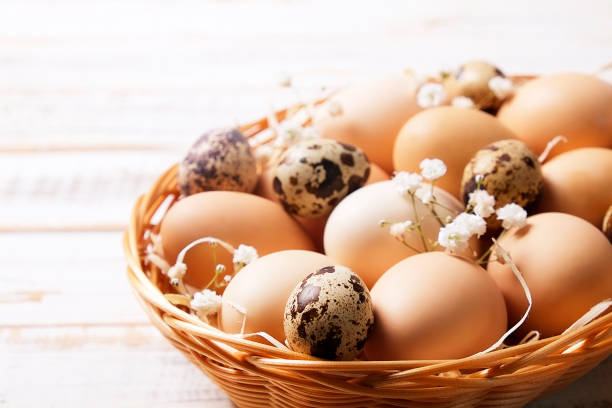 istock Traditional easter card template with unpainted mixed organic eggs in wicker basket with hay and decorative wildflowers. 926650612