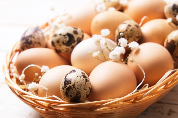 istock Traditional easter card template with unpainted mixed organic eggs in wicker basket with hay and decorative wildflowers. 926650660