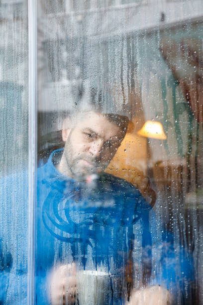 istock Portrait of man holding coffee cup by window 926654442