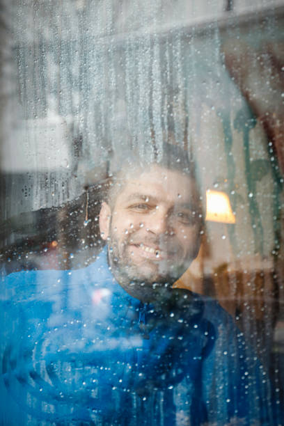 istock Portrait of man holding coffee cup by window 926654578