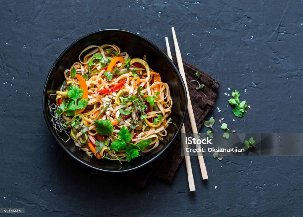 Pad Thai verdure vegetariane udon noodles in uno sfondo scuro, vista dall'alto. Cibo vegetariano in stile asiatico. Spazio di copia - Foto stock royalty-free di Noodle