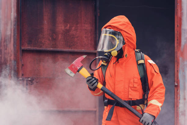 istock Firefighter holding axe in fire and smoke, Firemen fighting raging fire with huge flames of burning, Fire prevention and extinguishing concept 926678210