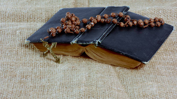 istock An open old book with a rosary in a hard cover lying on the jute 926689632