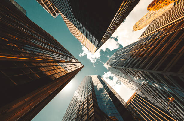 niedrigen winkel blick auf die wolkenkratzer in new york city - office building fotos stock-fotos und bilder