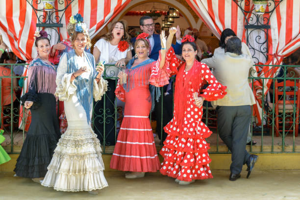 группа друзей, одетых в традиционные костюмы и наслаждаясь на апрельской ярмарке в севилье. - train spain seville europe стоковые фото и изображения