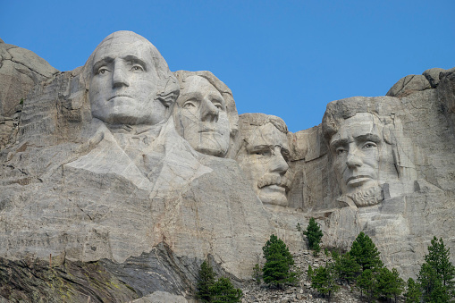 The Mount Rushmore National Memorial is a sculpture carved into the granite face of Mount Rushmore near Keystone, South Dakota, in the United States. Mount Rushmore features 60-foot sculptures of the heads of former United States presidents (in order from left to right) George Washington, Thomas Jefferson, Theodore Roosevelt and Abraham Lincoln.