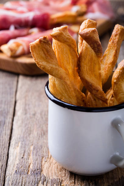 빵 스틱 소박한 흰색 머그잔에 치즈 퍼프 페이스 트리와 함께 - twisted cheese biscuit pastry 뉴스 사진 이미지