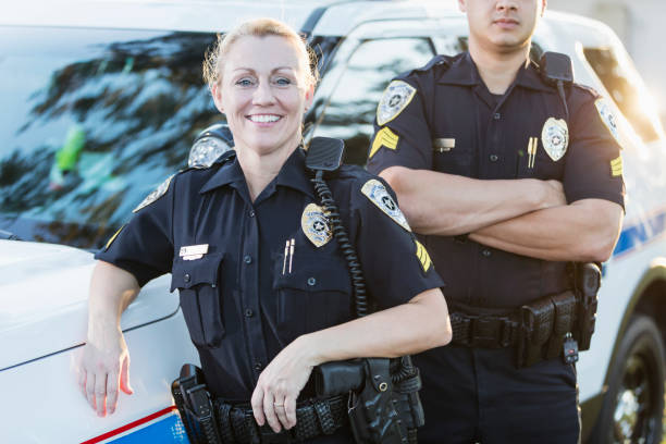 istock Policewoman and partner next to squad car 926718862