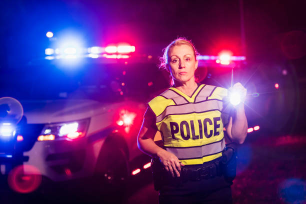 istock Policewoman at night with flashlight, emergency lights 926720838