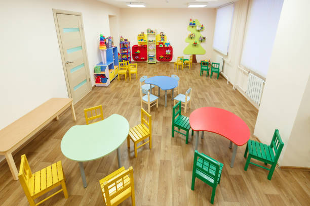 istock Spacious light pink colored game room with tables for classes in the kindergarten 926723722
