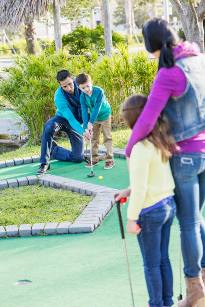 istock Family playing miniature golf, dad helping son 926724002