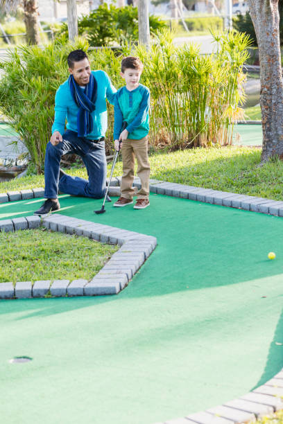 istock Father and son playing miniature golf 926726156
