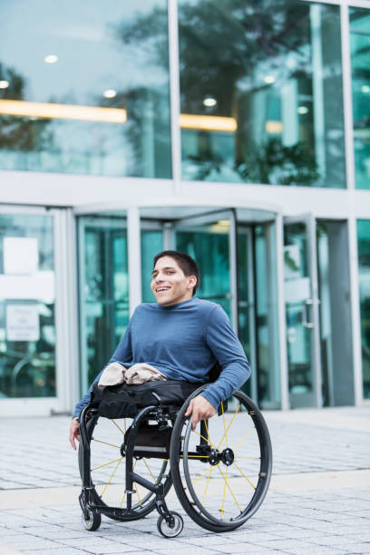 istock Young man in wheelchair on city sidewalk 926727298