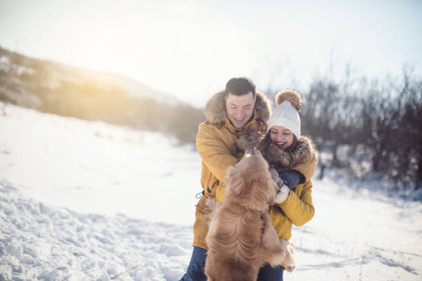 istock Love couple with dog having fun on snow 926729906
