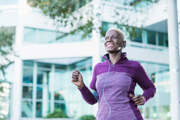 старшая афро-американская женщина, осуществляющая на открытом воздухе - senior adult running jogging senior women стоковые фото и изображения