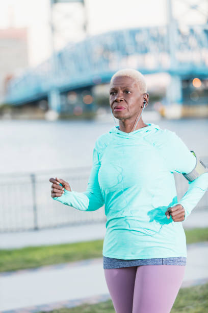 istock Senior African-American woman running on waterfront 926737358