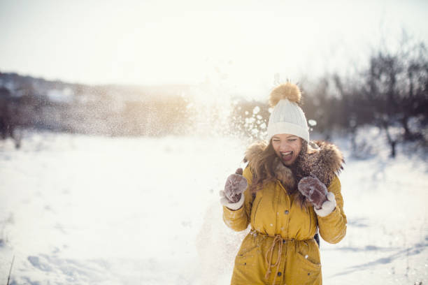 Young couple having snowball fight on a winter day