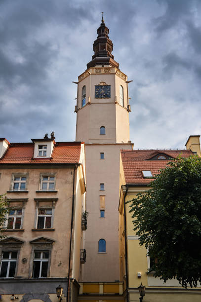 Houses and a gothic church tower with a clock in the city of Swidnica