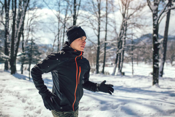 istock Young man running at winter in park 926749600