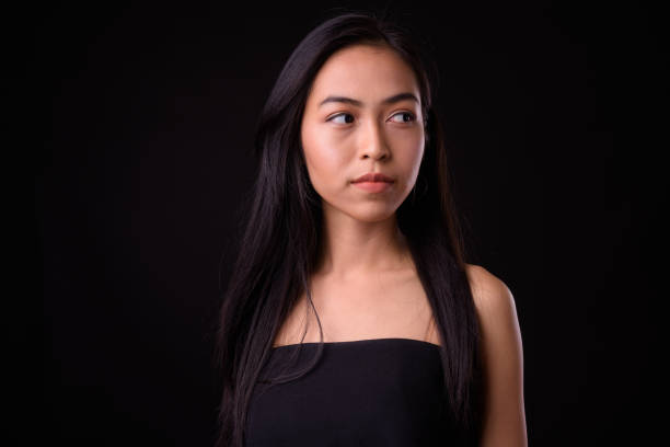 istock Young beautiful Asian woman against black background 926753922