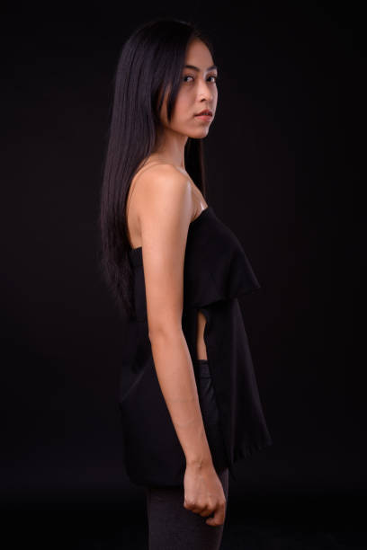 istock Young beautiful Asian woman against black background 926753942