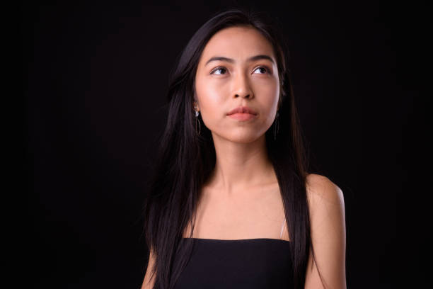 istock Young beautiful Asian woman against black background 926753964