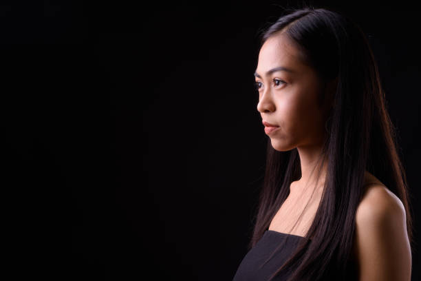 istock Young beautiful Asian woman against black background 926757242