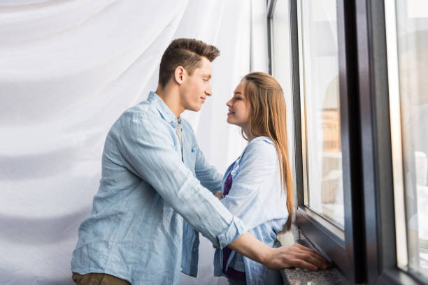 istock happy couple looking at each other near window 926763372