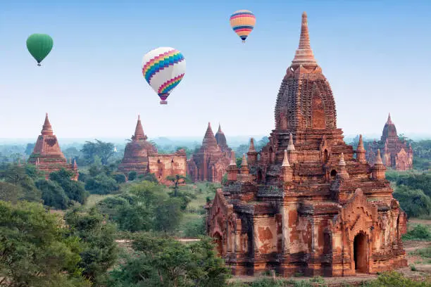 Colorful hot air balloons flying over Bagan, Mandalay division, Myanmar. Bagan's prosperous economy built over 10000 temples between the 11th and 13th centuries.