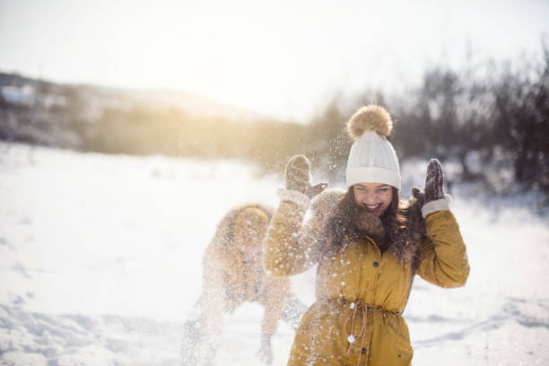 Young couple having snowball fight on a winter day