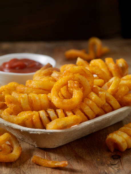 Spicy Curly Fries with Ketchup Spicy Curly Fries with Ketchup in a Take out Container curly fries stock pictures, royalty-free photos & images