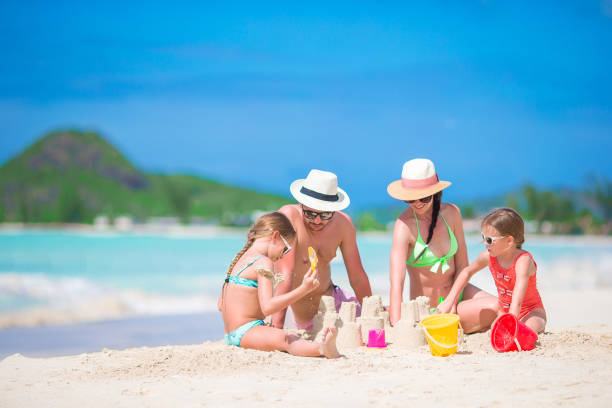 istock Family making sand castle at tropical white beach 926779680