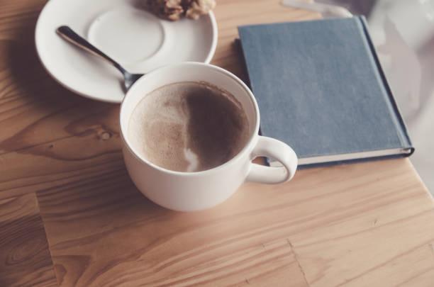 istock Coffee cup on wood table with blue blook 926784142