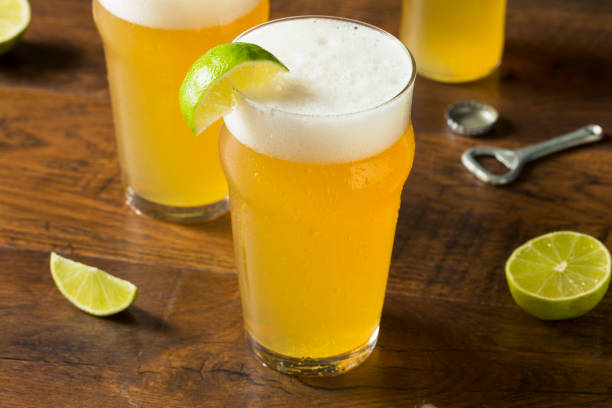 Alcoholic Refreshing Mexican Beer with Lime Alcoholic Refreshing Mexican Beer with Lime in a Pint Glass lager stock pictures, royalty-free photos & images