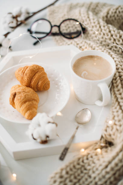 istock Cozy home breakfast, warm blanket, coffee and croissant on white 926786290