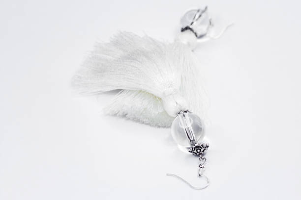 istock White handmade earrings-tassels on a white background. 926790680