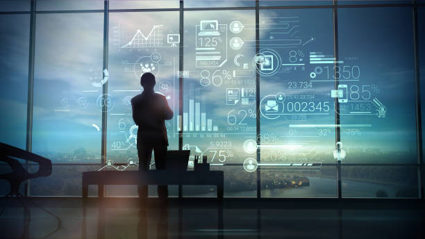 Silhouette of the man in the office and corporate infographic A silhouette of a man stands on the background of large office windows and views a hologram of corporate infographic with work data. graphite photos stock pictures, royalty-free photos & images