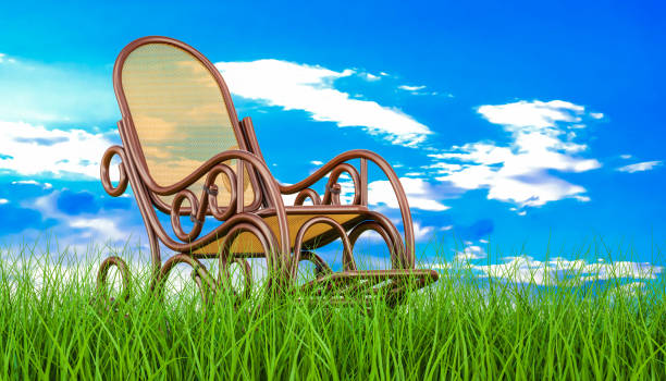 istock Rocking chair in green grass against blue sky, 3d rendering 926802178