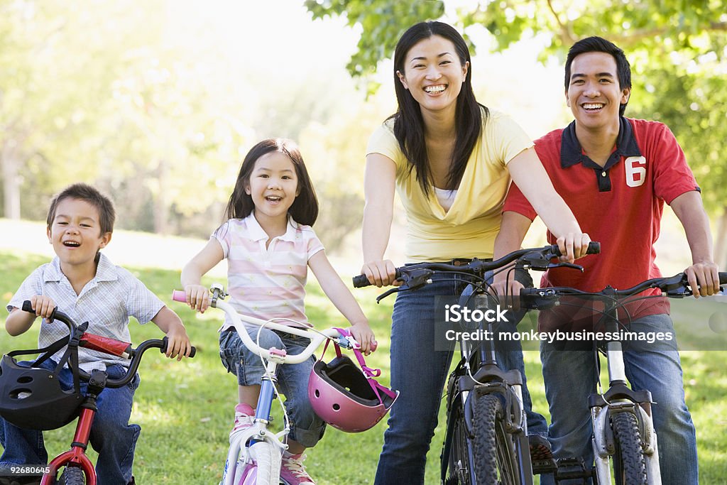 Familia en las bicicletas al aire libre Sonriendo - Foto de stock de Andar en bicicleta libre de derechos