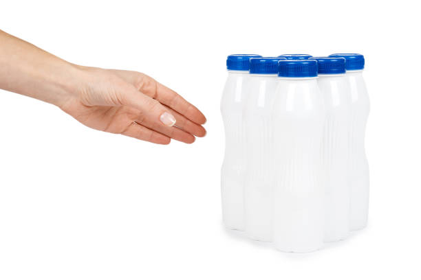 istock White plastic bottle with drink yogurt or milk with hand. Isolated on white background. Container merchandise template 926806490