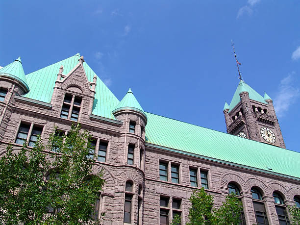 istock Large grey building with green roof against a blue sky. 92680928