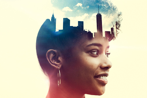 The profile of a woman's head, a New York City skyline double exposed with the image.  A conceptual depiction of smart cities, and the people who shape them.