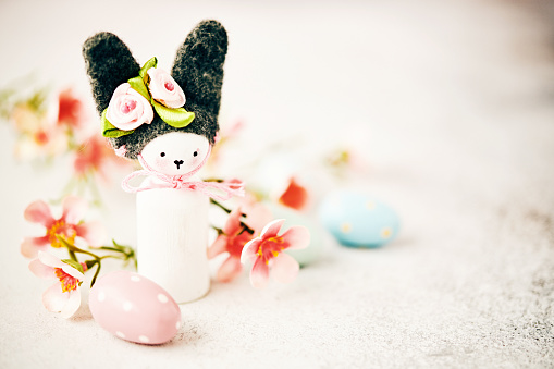 Handmade Easter bunny with pastel colored flowers and Easter eggs