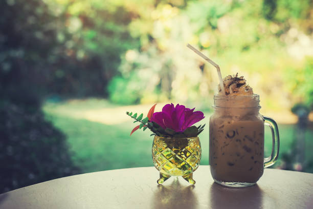 istock Iced coffee and flower  vase on the table style vintage. 926813546