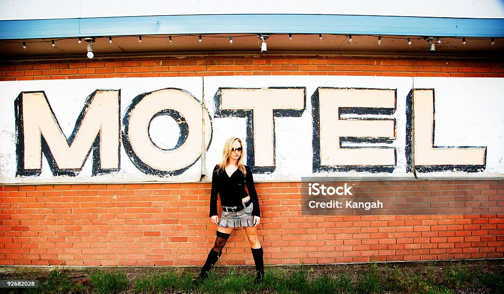 MOTEL Female standing in front of a motel sign. Image has been colorized and will have a slight grain. Adult Stock Photo