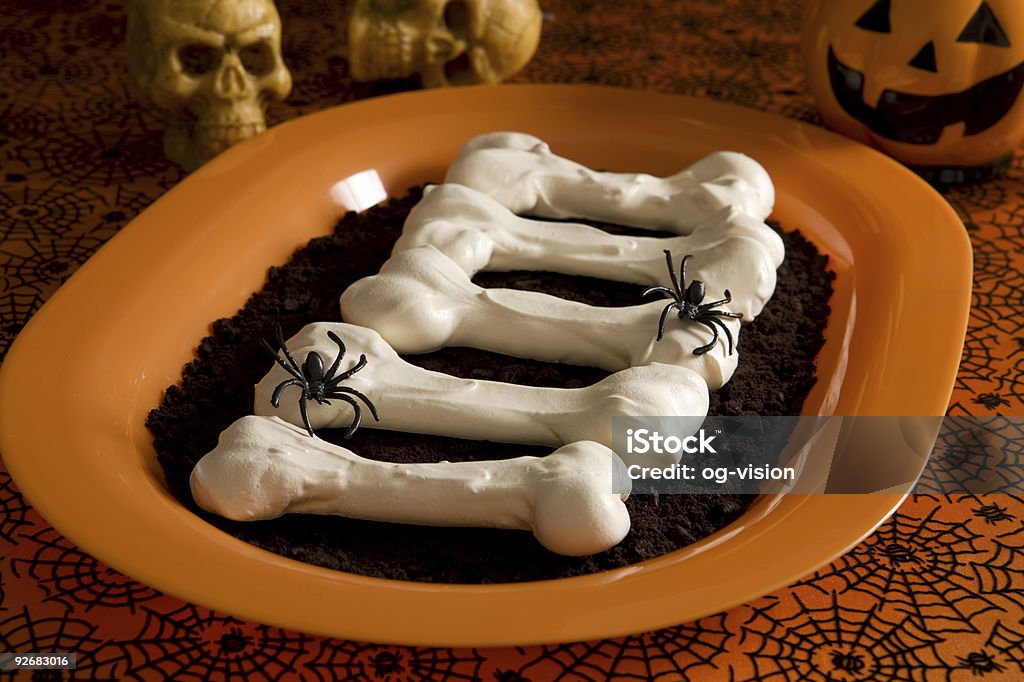 Halloween meringue bones Meringue bones on dirt (crashed  cookie Cookies) surrounded by halloween decorations Animal Bone Stock Photo