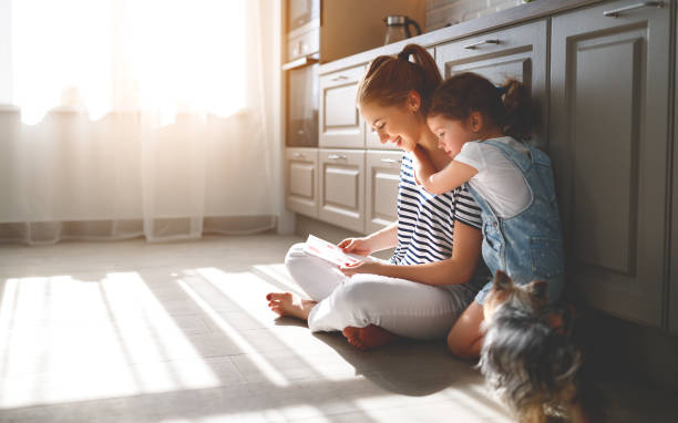 szczęśliwy dzień matki! córka dziecko gratuluje matce i czytać pocztówkę - floor relaxation women home interior zdjęcia i obrazy z banku zdjęć