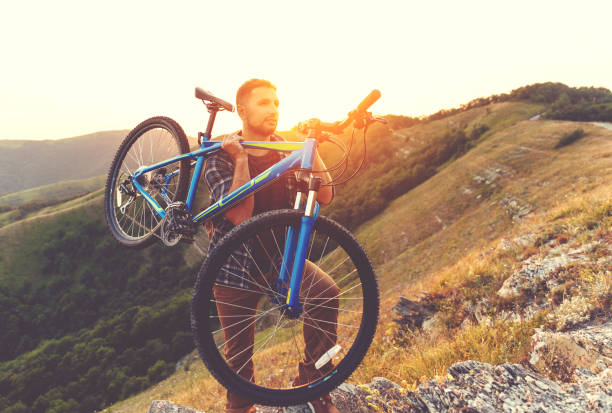 istock cycling. young man with bicycle on nature in mountains 926870660
