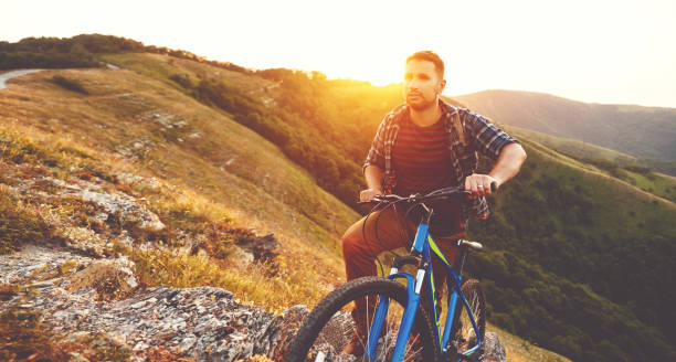 istock cycling. young man with bicycle on nature in mountains 926870782